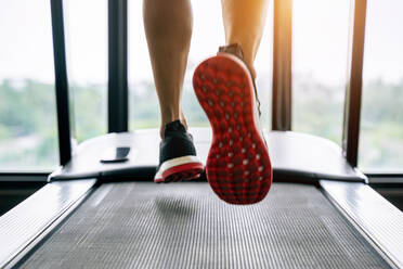 Niedriger Ausschnitt einer Person, die auf dem Laufband im Fitnessstudio trainiert - EYF01652