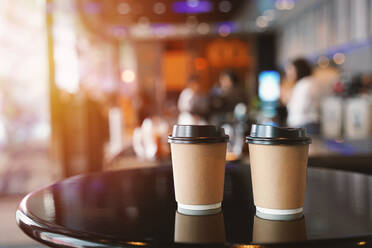 Nahaufnahme von Einweg-Kaffeebechern auf dem Tisch eines Cafés - EYF01771