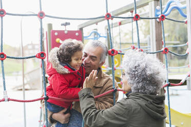 Großeltern spielen mit Enkel auf dem Spielplatz - CAIF24517