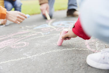 Girl drawing with sidewalk chalk - CAIF24543