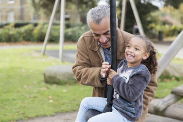 Glücklicher Großvater und Enkelin auf dem Spielplatz - CAIF24577