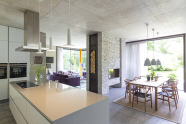 Moderne offene Küche und Esszimmer mit gemauertem Kamin - CAIF24695