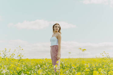 Junge Frau auf einer Blumenwiese im Frühling - ERRF02910