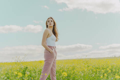 Junge Frau auf einer Blumenwiese im Frühling, lizenzfreies Stockfoto