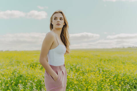 Junge Frau auf einer Blumenwiese im Frühling, lizenzfreies Stockfoto