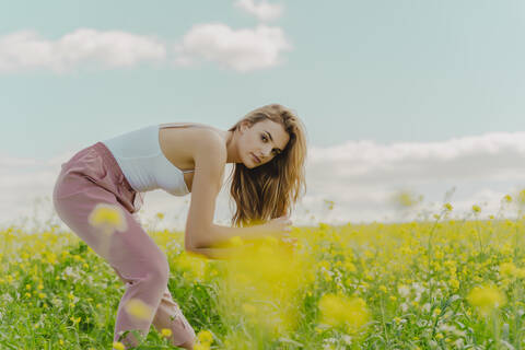 Porträt einer jungen Frau auf einer Blumenwiese im Frühling, lizenzfreies Stockfoto