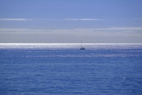 Spanien, Einsames Segelboot auf dem blauen Wasser des Atlantischen Ozeans, lizenzfreies Stockfoto