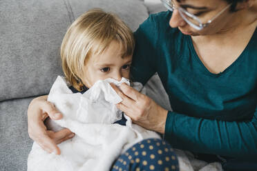 Mother blowing little daughter's nose - JRFF04251