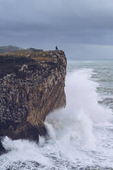 Mann auf einer Klippe stehend, Bufones de Pria, Spanien - RSGF00249