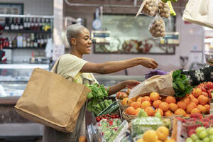 Frau kauft Lebensmittel in einer Markthalle - AFVF05901