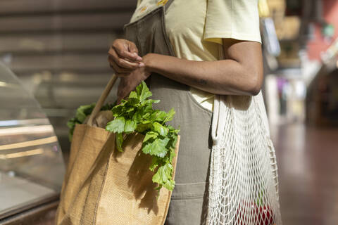 Mid section of woman buying groceries in a market hall stock photo