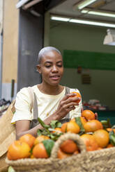 Frau kauft Mandarinen in einer Markthalle - AFVF05909