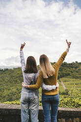 Zwei glückliche junge Frauen in ländlicher Landschaft mit Blick auf die Aussicht, Greve in Chianti, Toskana, Italien - JPIF00574
