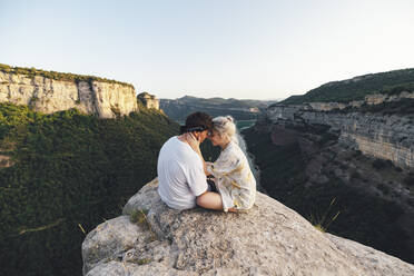 Young couple in love sitting on viewpoint, Sau Reservoir, Catalonia, Spain - AMAF00012