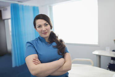 Portrait confident female nurse in hospital room - CAIF24770