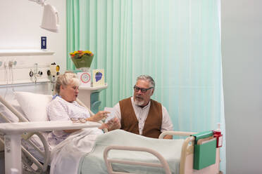 Älterer Mann besucht seine Frau, die im Krankenhauszimmer ruht - CAIF24792