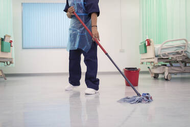 Weiblicher Krankenpfleger wischt den Boden einer Krankenhausstation - CAIF24797