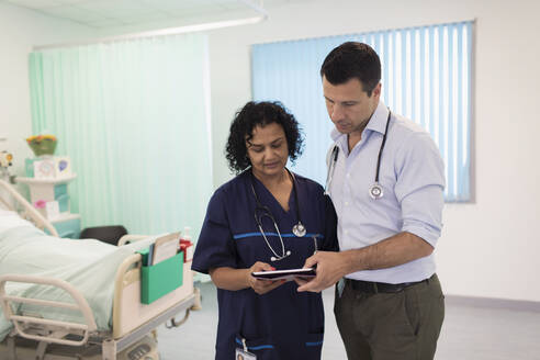 Ärzte mit digitalem Tablet bei der Visite, Beratung im Krankenhauszimmer - CAIF24809