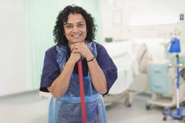 Porträt einer lächelnden, selbstbewussten Krankenpflegerin, die eine Krankenhausstation reinigt - CAIF24821