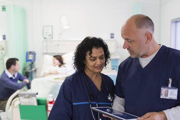 Ärzte mit digitalem Tablet bei der Visite, Beratung im Krankenhauszimmer - CAIF24859