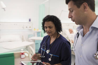 Ärzte mit digitalem Tablet bei der Visite, Beratung im Krankenhauszimmer - CAIF24868