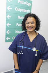 Porträt einer selbstbewussten, fröhlichen Ärztin im Krankenhausflur - CAIF24870