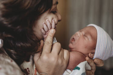 Close up detail of mother in hospital touching newborn son's hand - CAVF77658
