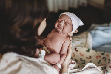 Newborn boy with hat in hospital making funny face - CAVF77659