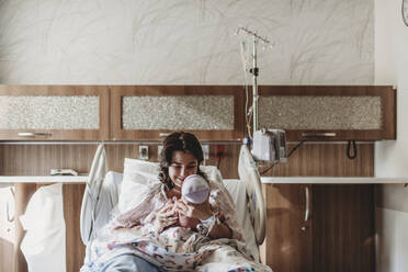 Mittelansicht einer Mutter im Krankenhausbett mit Blick auf ihren neugeborenen Sohn - CAVF77664