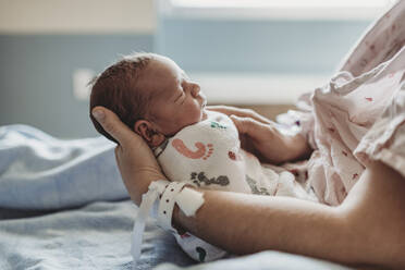 Seitenansicht eines neugeborenen Jungen im Profil mit Hut im Krankenhaus - CAVF77667
