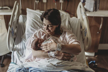 Mittelansicht einer Mutter im Krankenhausbett mit Blick auf ihren neugeborenen Sohn - CAVF77674