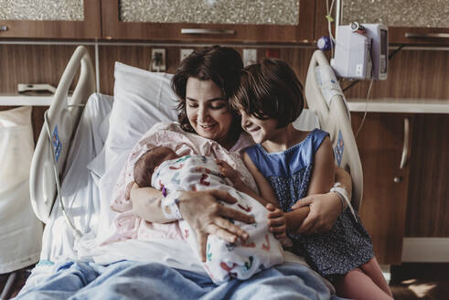 Mittelansicht einer Mutter, die ihren neugeborenen Sohn hält und sich mit ihrer Schwester trifft - CAVF77687