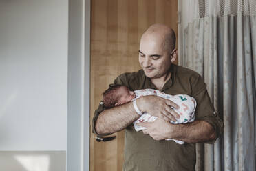 Vater hält neugeborenen Jungen in Decken eingewickelt im Krankenhaus - CAVF77704