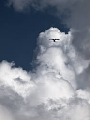 Propellerflugzeug hoch oben in einem bewölkten Himmel - CAVF77759