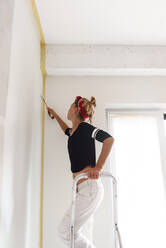 Girl paints the walls in the house - CAVF77763