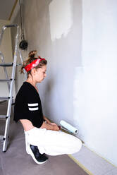 Girl paints the walls in the house - CAVF77770