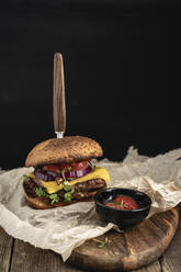 Studioaufnahme eines verzehrfertigen Hamburgers mit roter Paprika, Zwiebeln und Käse - VPIF02176