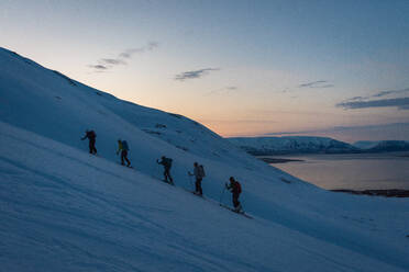 Group backcountry skiing in Iceland during sunrise - CAVF77811