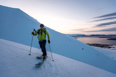 Man backcountry skiing in Iceland at sunrise - CAVF77815