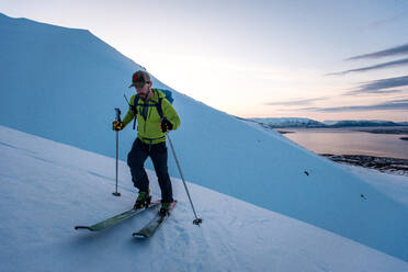 Man backcountry skiing in Iceland at Sunrise - CAVF77817