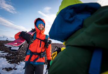Frau im Gespräch mit Mann mit Skiern in Island - CAVF77834