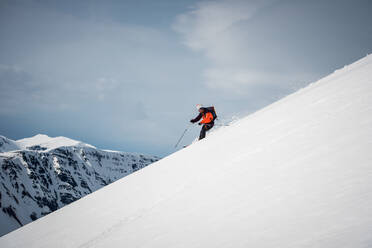 Mann beim Skifahren in Island mit Bergen im Hintergrund - CAVF77852