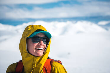 Frau lachend im Winter mit Kapuze und Hut ein - CAVF77867