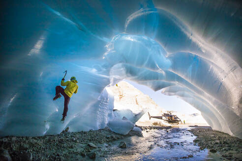 Mann beim Eisklettern in einer Eishöhle während einer Luxusabenteuerreise. - CAVF77922