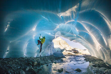 Man ice climbing in ice cave during luxury adventure tour. - CAVF77923