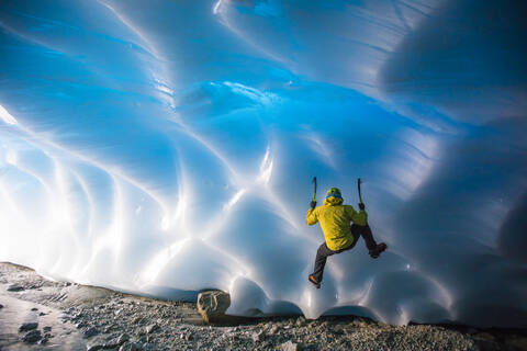 Bergsteiger beim Eisklettern auf Gletschereis in einer Eishöhle., lizenzfreies Stockfoto