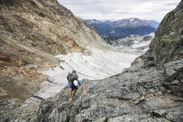 High angle view of backpacker hiking up a rocky mountain. - CAVF77965
