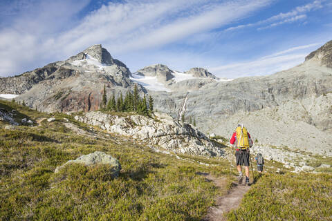 Rear view of backpackers approaching Locomotive Mountain. stock photo