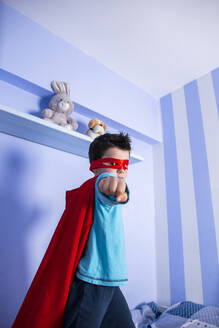 Kleiner Junge spielt Superheld, stehend auf seinem Bett - LJF01480