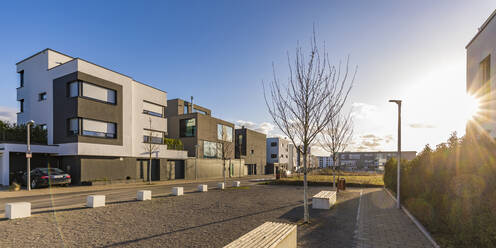 Germany, Baden-Wurttemberg, Ludwigsburg, Driveway of modern suburb houses at sunset - WDF05882